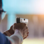 man pointing handgun at target